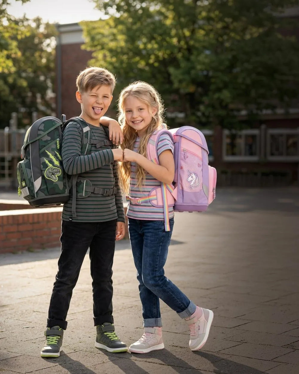 Mädchen und Junge mit Schulranzen auf dem Schulhof